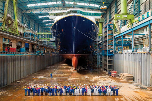 The staff of Meyer Werft standing in front of Spirit of Discovery